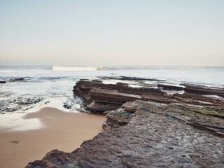 view of beach, cliffs and breaking waves