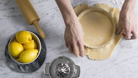 Pâtissier Electrolux remplissant avec attention le moule de l'appareil à tarte
