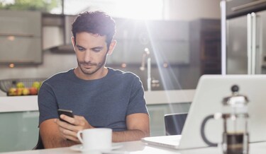man scrolt op zijn telefoon